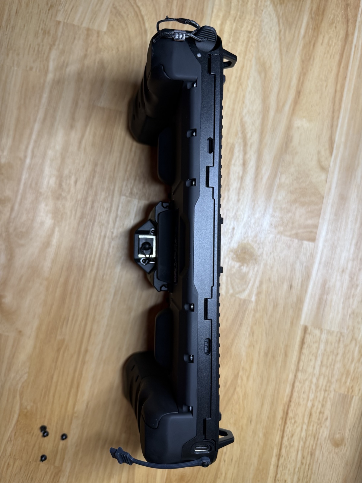 Side profile of the fully assembled controller, showing the bezel seated flush against the rear shell with the side rail, screws, and USB-C port visible
